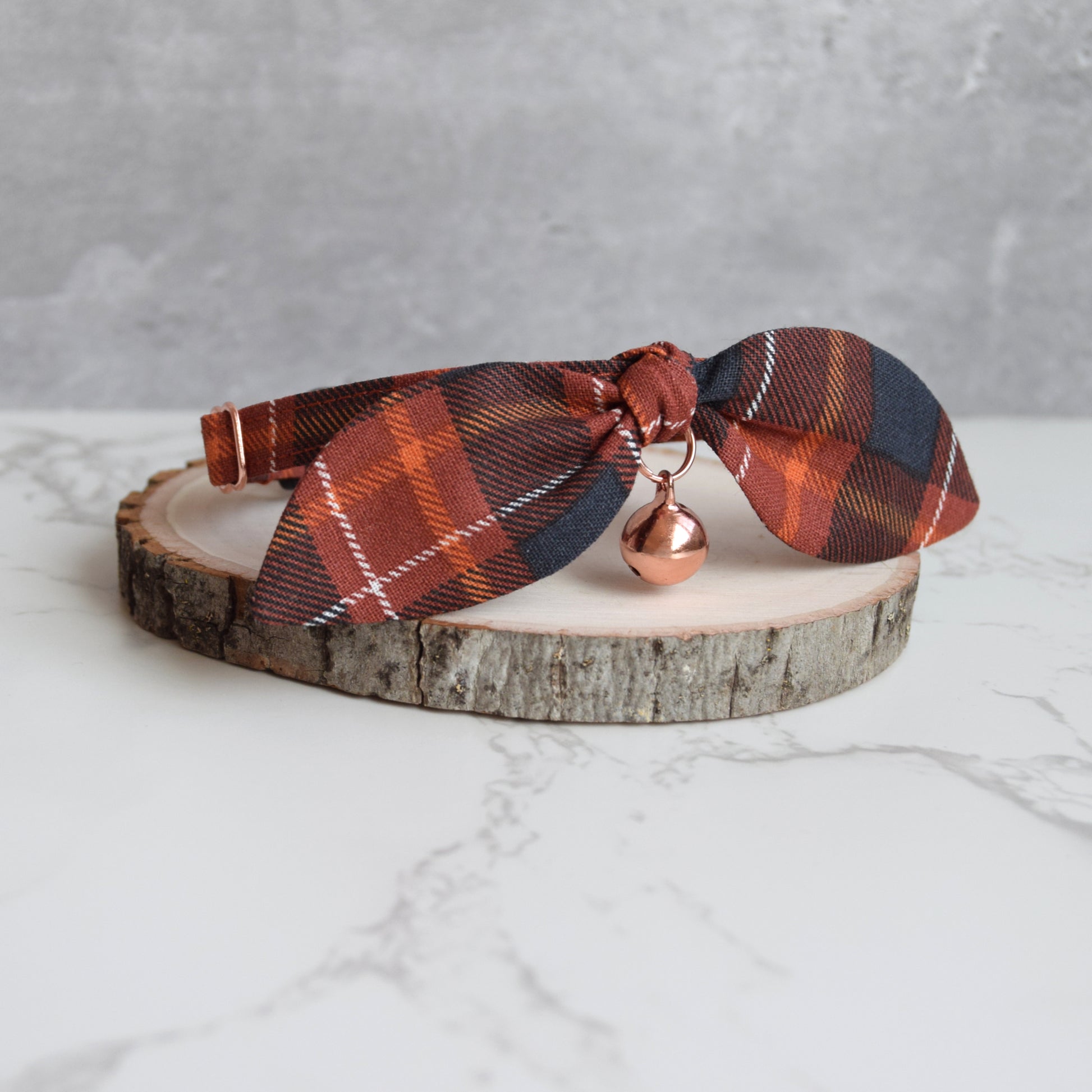 side view burnt orange plaid cat collar with rose gold bell